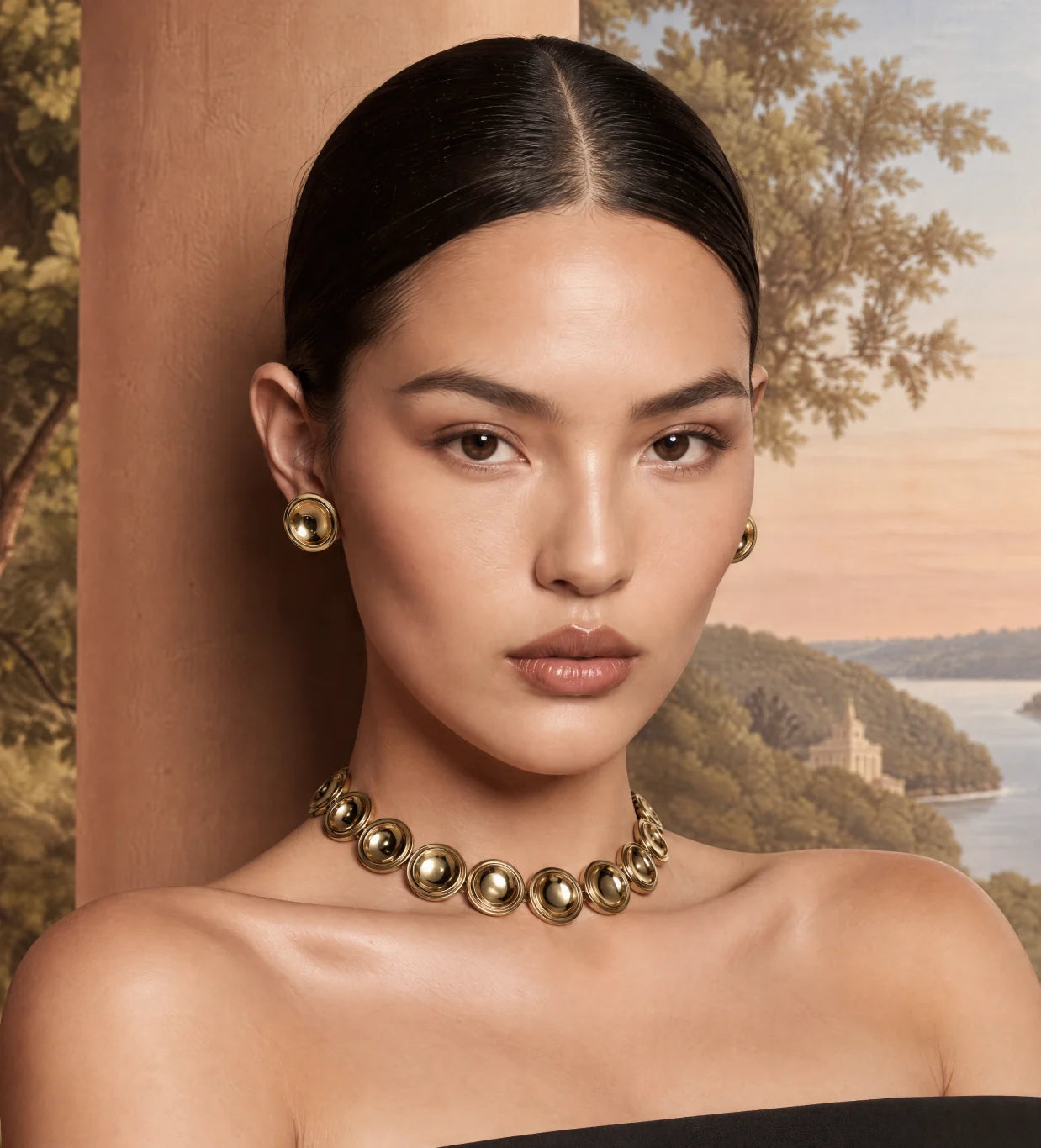 Close portrait of a model wearing the Patera Necklace and Earrings in gold