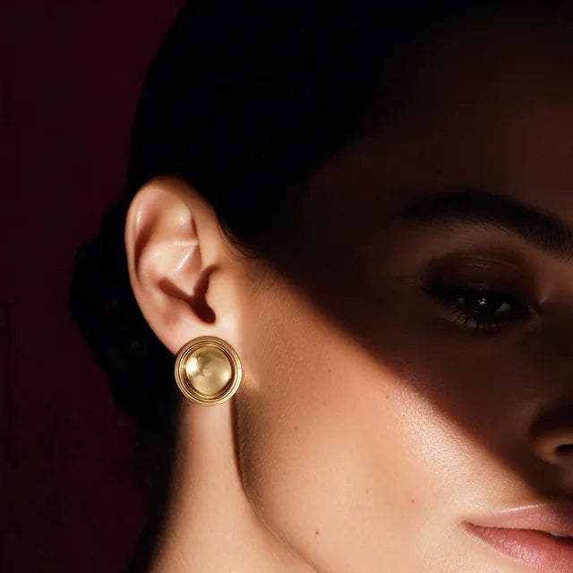 Close view of a model wearing a Patera Earring in gold