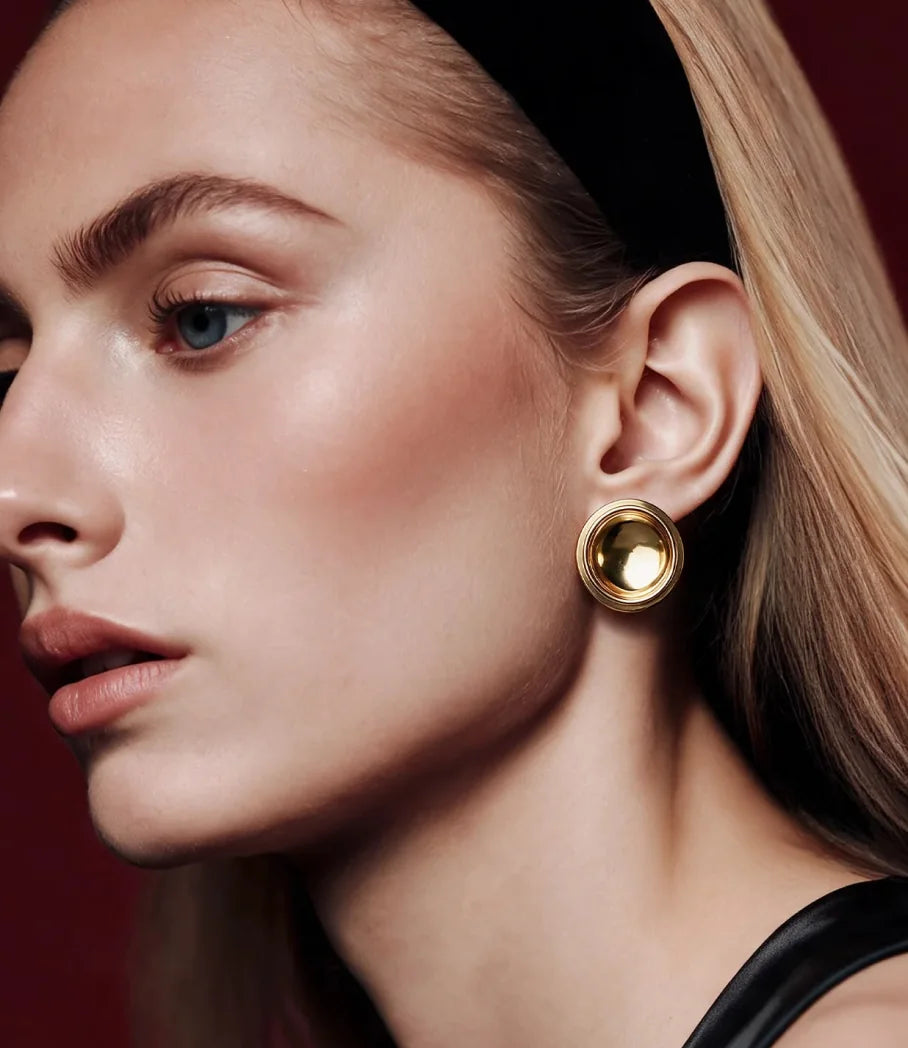 Close profile of a model wearing a Patera Earring in gold
